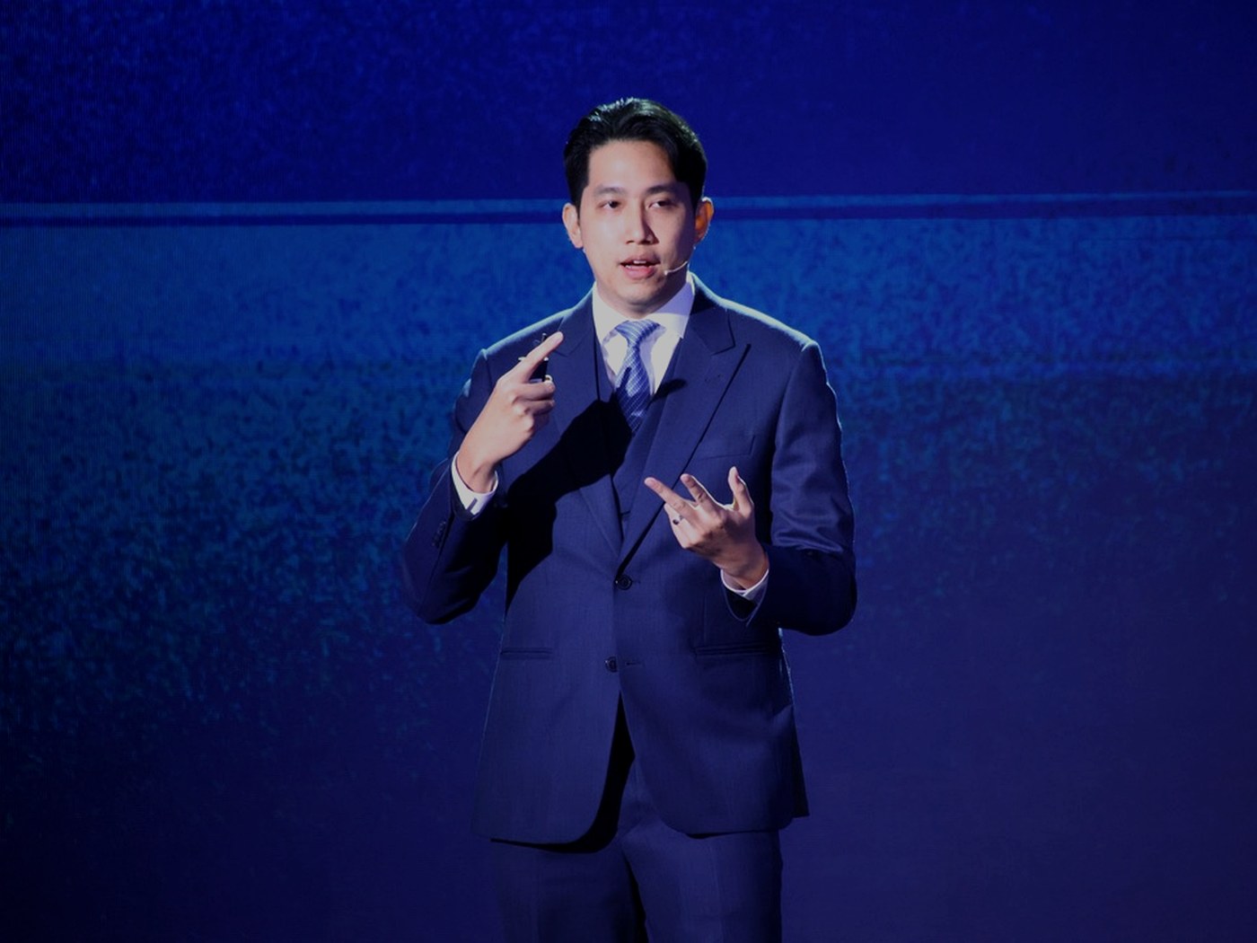 Keynote speaker on a blue-lit stage